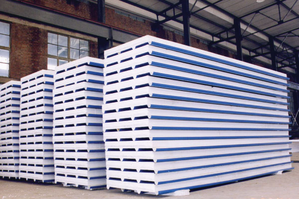 Roll-formed color coated steel sheets utilized as structural outer facing on insulated panels